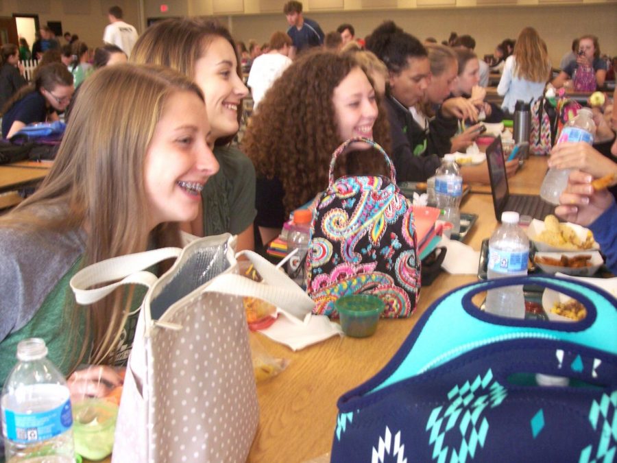 Ashley Dukehart (9), Julia Trei (9), and Brynn Taulton (9) smile as they share a funny moment with their friends.
