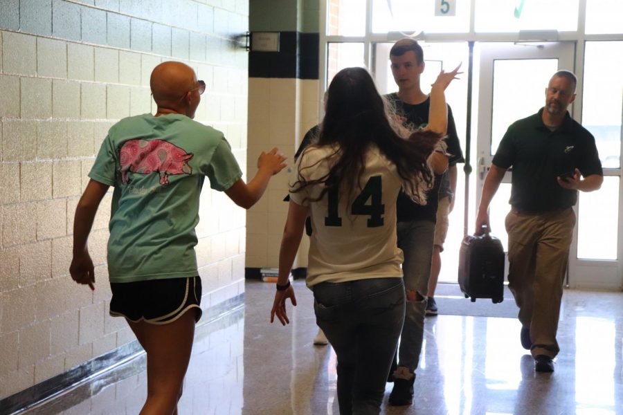 Cass Martin (12) and Hannah Kimmel (11) lip sync their portion of the Lip Dub project as Austin Thomas (10) films and Mr. Kevin Gustafson (Faculty) carries a speaker with the music.