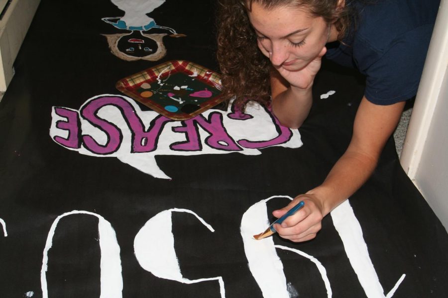 President of Student Council, Sarah Kimmel (12) paints a sign for spirit week.