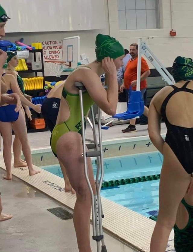 Kylee+Long+puts+on+her+swim+cap+before+her+first+race.+