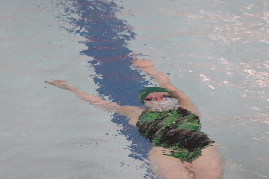 After her kick off the wall, Rhia Peterson (9) starts her second lap in the 100 meter Backstroke race. 